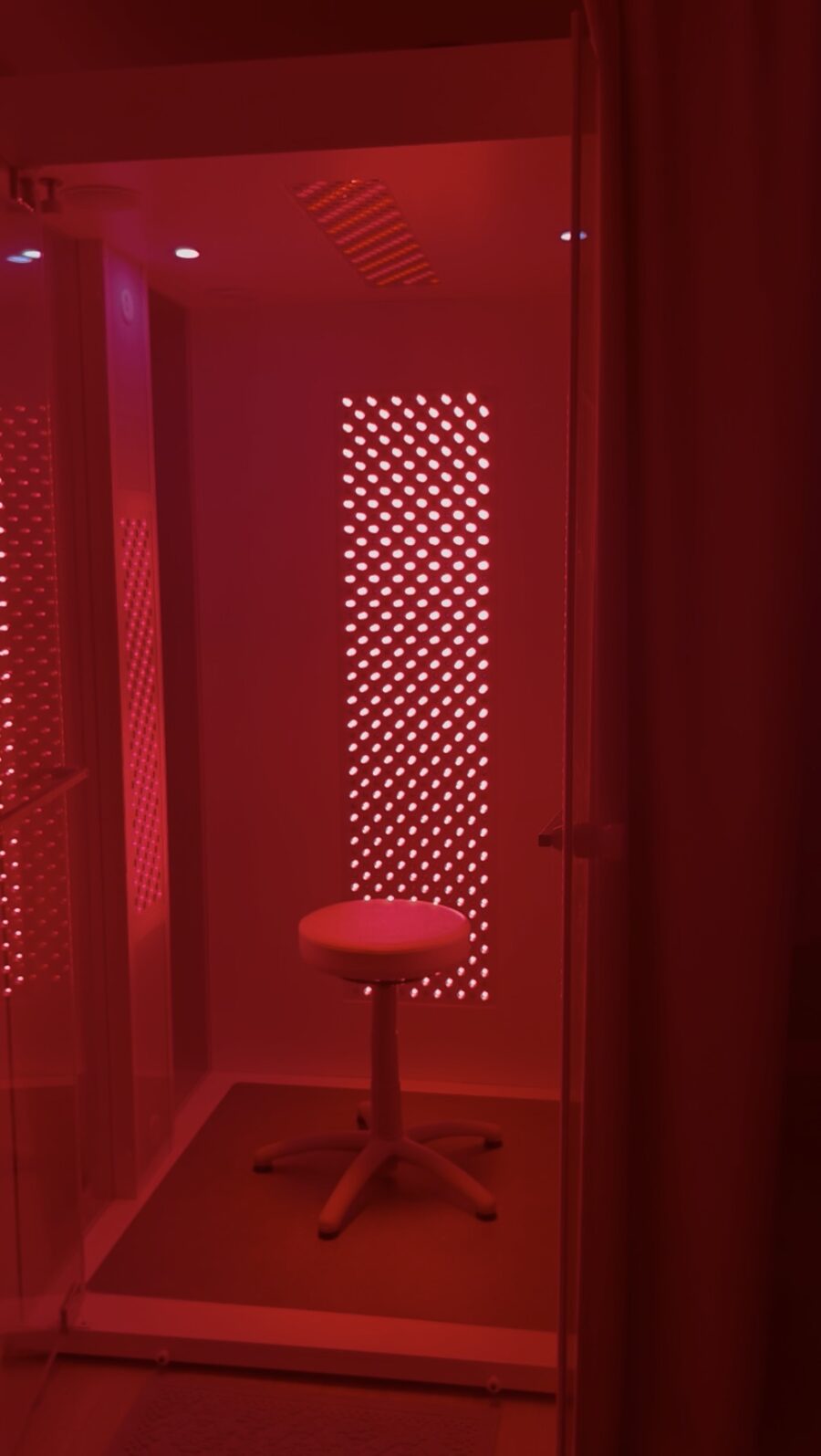 Interior of the HaloRed O2 Vitality Booth with LED therapy panels and treatment stool